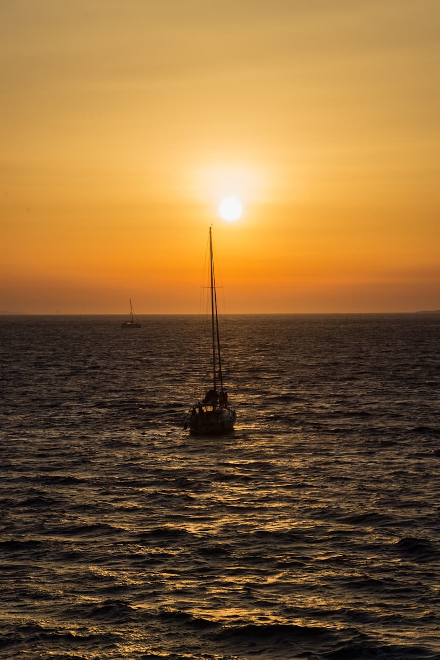 A yacht on calm water as the light turns gold off the coast