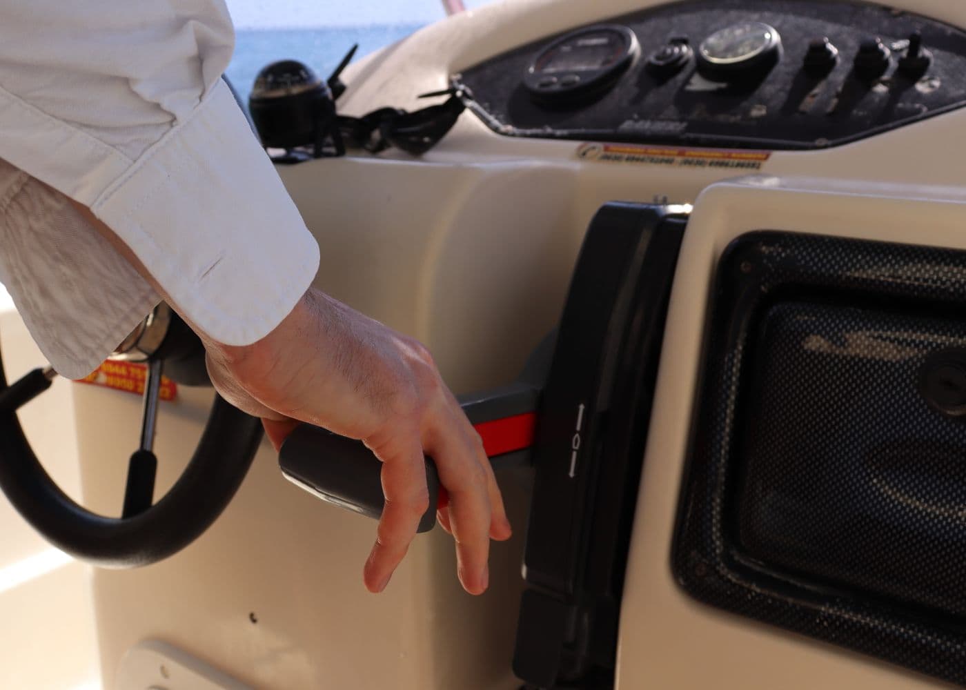 A hand on the helm controls, running the day on the water