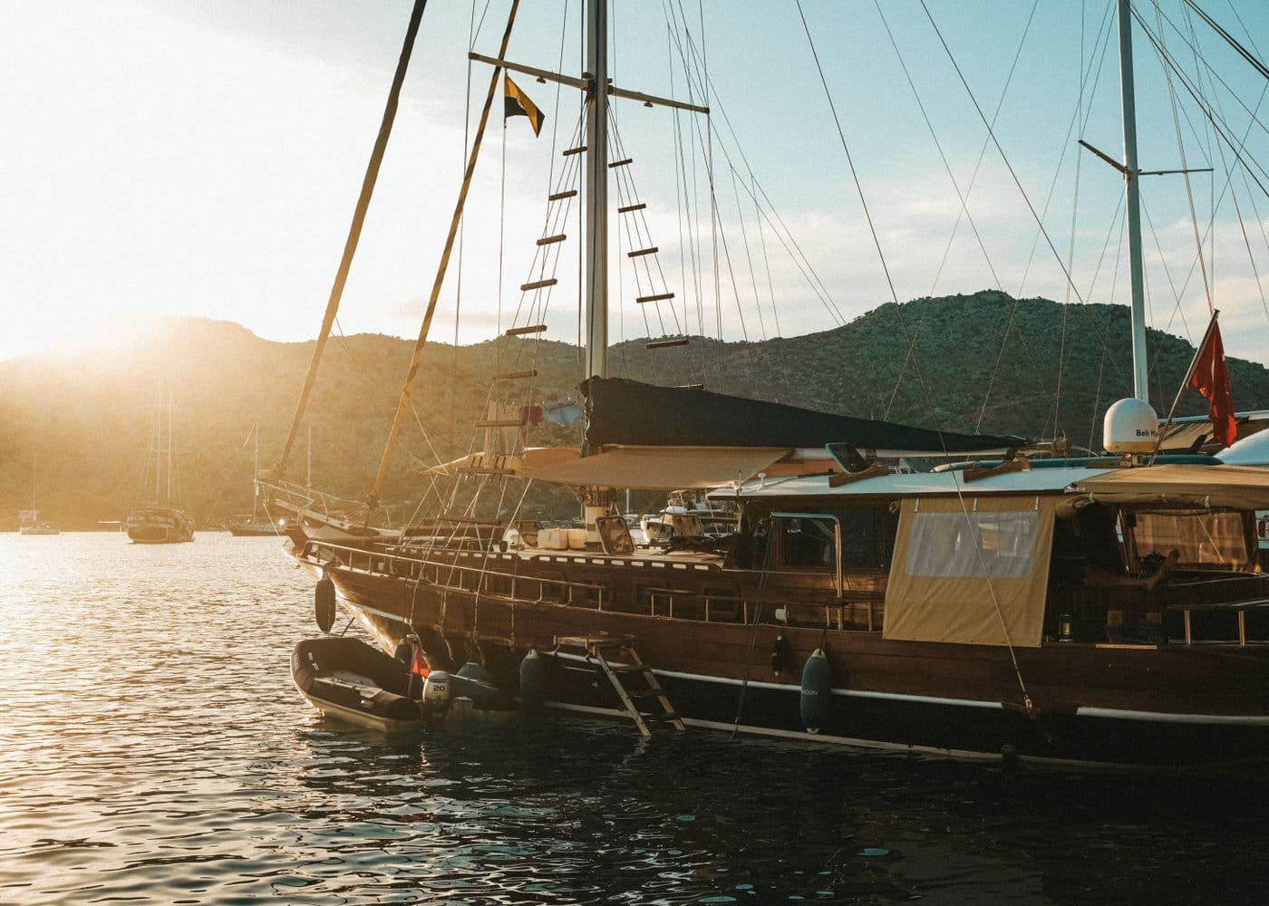 A yacht at anchor near the coast at sunset